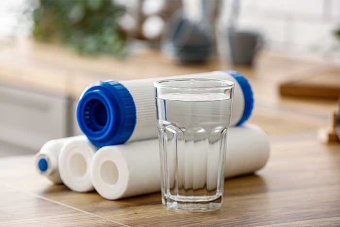 Glass of water with filters on wooden table